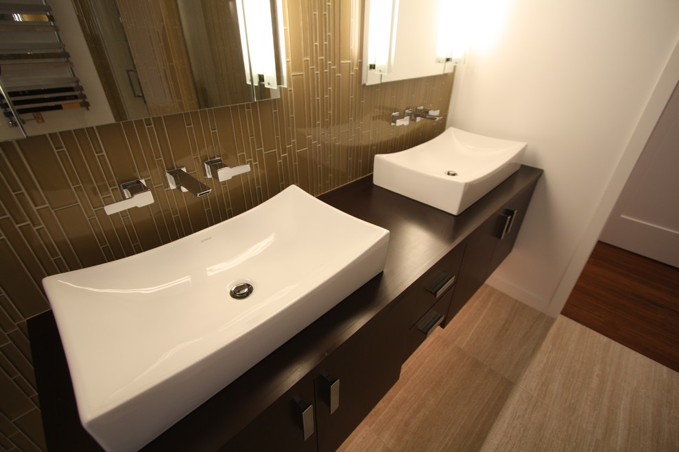 Cette photo montre une salle de bain tendance en bois foncé avec une vasque, un placard à porte plane, un plan de toilette en bois, un mur blanc et un sol en carrelage de céramique.
