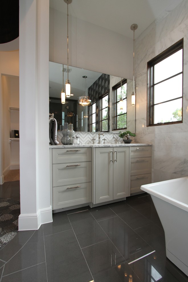 Bild på ett mellanstort vintage en-suite badrum, med ett undermonterad handfat, släta luckor, vita skåp, marmorbänkskiva, ett fristående badkar, svart kakel, porslinskakel, vita väggar och klinkergolv i porslin