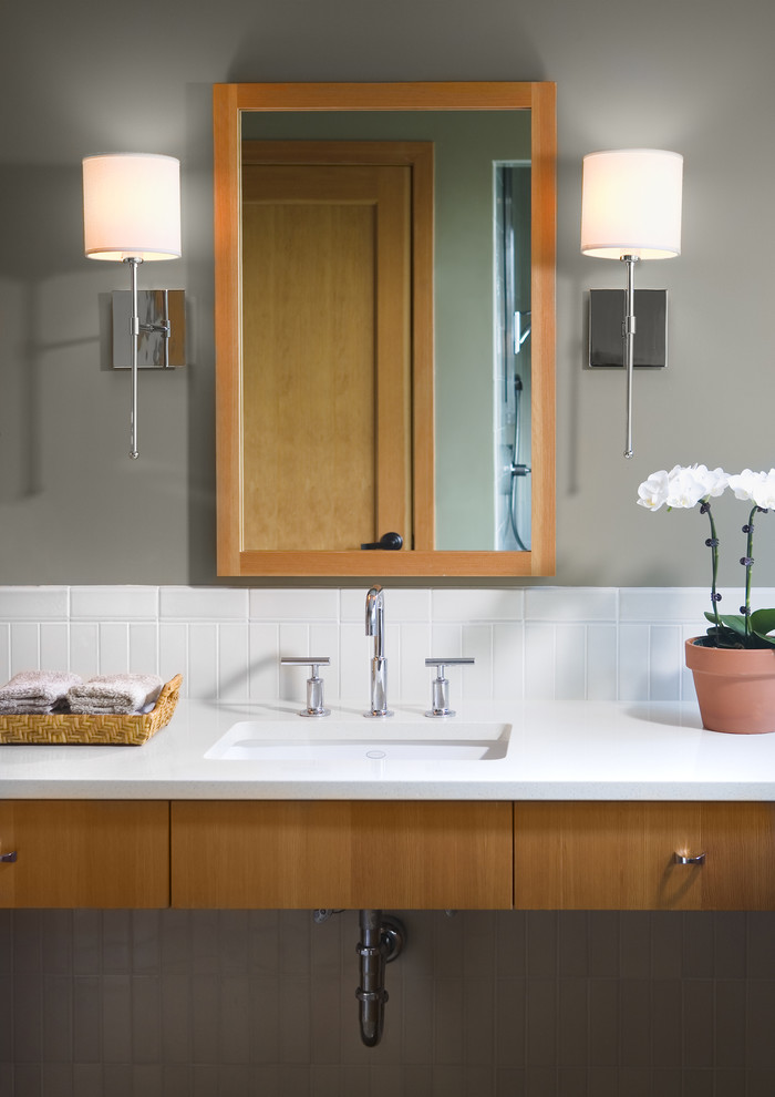 Idée de décoration pour une salle d'eau design en bois clair de taille moyenne avec un placard à porte plane, WC séparés, un carrelage blanc, des carreaux de céramique, un mur gris, un lavabo encastré et un plan de toilette en quartz modifié.