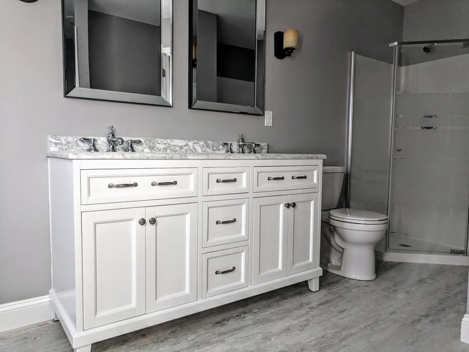 Aménagement d'une salle de bain classique avec un placard en trompe-l'oeil, des portes de placard blanches, une douche d'angle, WC à poser, un mur gris, un sol en vinyl, un lavabo encastré, un plan de toilette en marbre, un sol gris, une cabine de douche à porte battante et un plan de toilette gris.