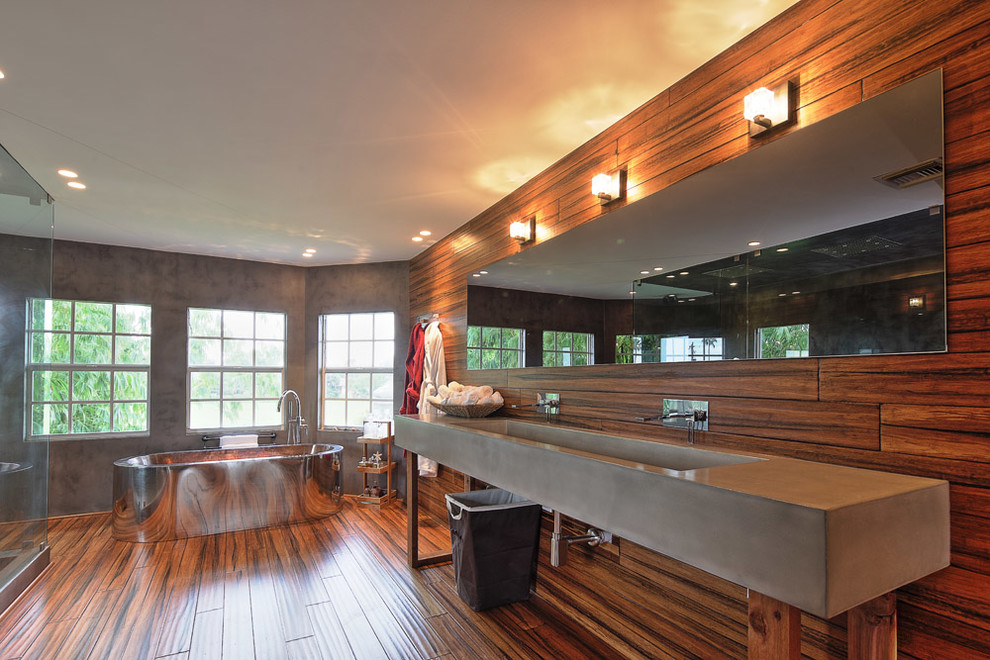 Пример оригинального дизайна: ванная комната в современном стиле с раковиной с несколькими смесителями, отдельно стоящей ванной, угловым душем и столешницей из бетона