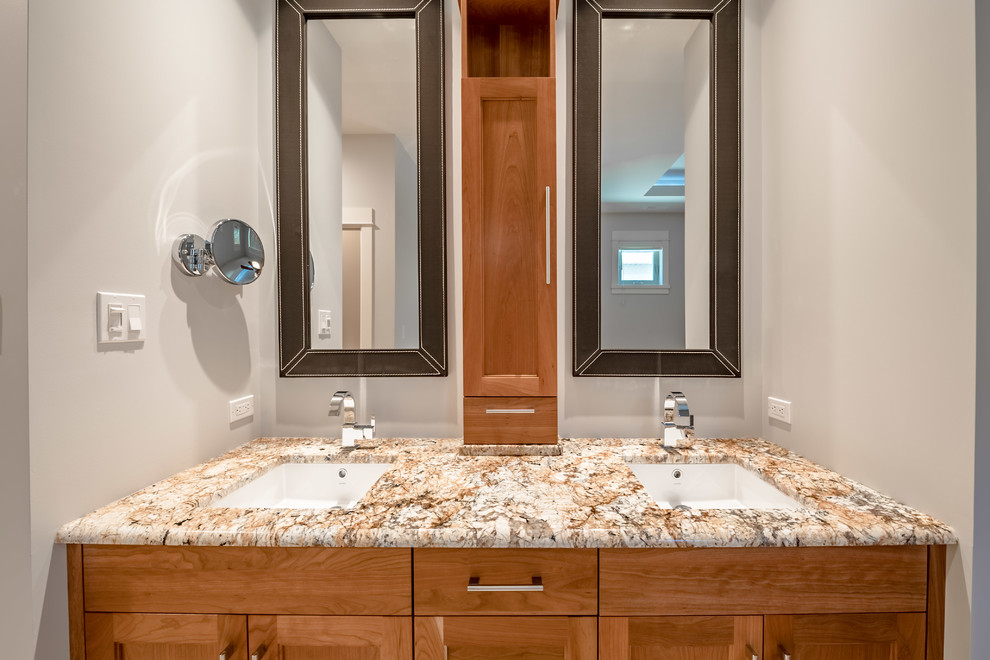 Immagine di una stanza da bagno con doccia design di medie dimensioni con ante in stile shaker, ante in legno scuro, pareti grigie, pavimento in vinile, lavabo sottopiano, top in granito, pavimento beige e top marrone