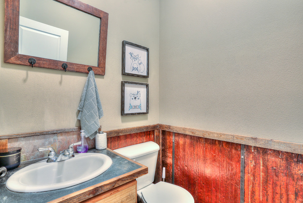 Foto de cuarto de baño rústico pequeño con puertas de armario con efecto envejecido, armarios con paneles lisos, sanitario de una pieza, lavabo encastrado, encimera de acero inoxidable y encimeras grises