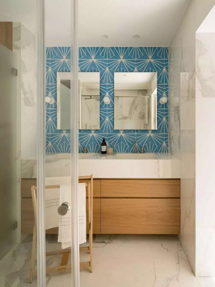 Medium sized coastal sauna bathroom in Other with flat-panel cabinets, light wood cabinets, a freestanding bath, a walk-in shower, blue tiles, porcelain tiles, tiled worktops, a hinged door, white worktops, double sinks, a built in vanity unit, white walls, cement flooring, a submerged sink, white floors and brick walls.