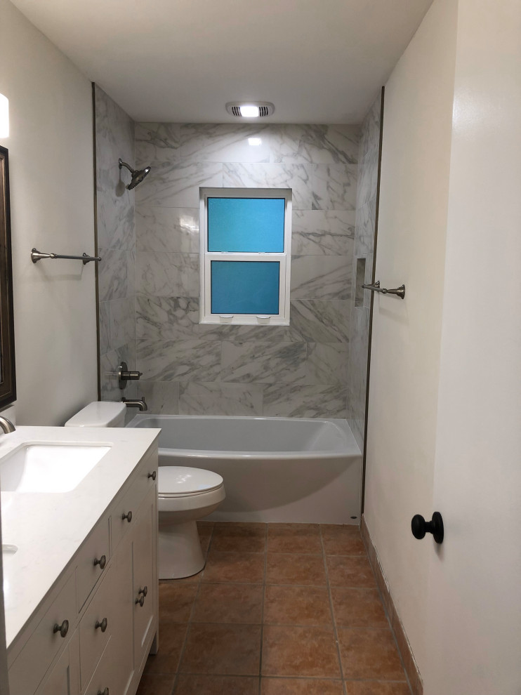Стильный дизайн: главная ванная комната среднего размера в классическом стиле с фасадами островного типа, белыми фасадами, накладной ванной, душем над ванной, унитазом-моноблоком, серой плиткой, керамогранитной плиткой, белыми стенами, полом из керамогранита, врезной раковиной, столешницей из искусственного камня, оранжевым полом, шторкой для ванной и белой столешницей - последний тренд