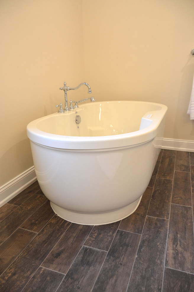 Large classic ensuite bathroom in Philadelphia with a submerged sink, freestanding cabinets, marble worktops, a freestanding bath, an alcove shower, a two-piece toilet, beige tiles, stone tiles, beige walls and porcelain flooring.