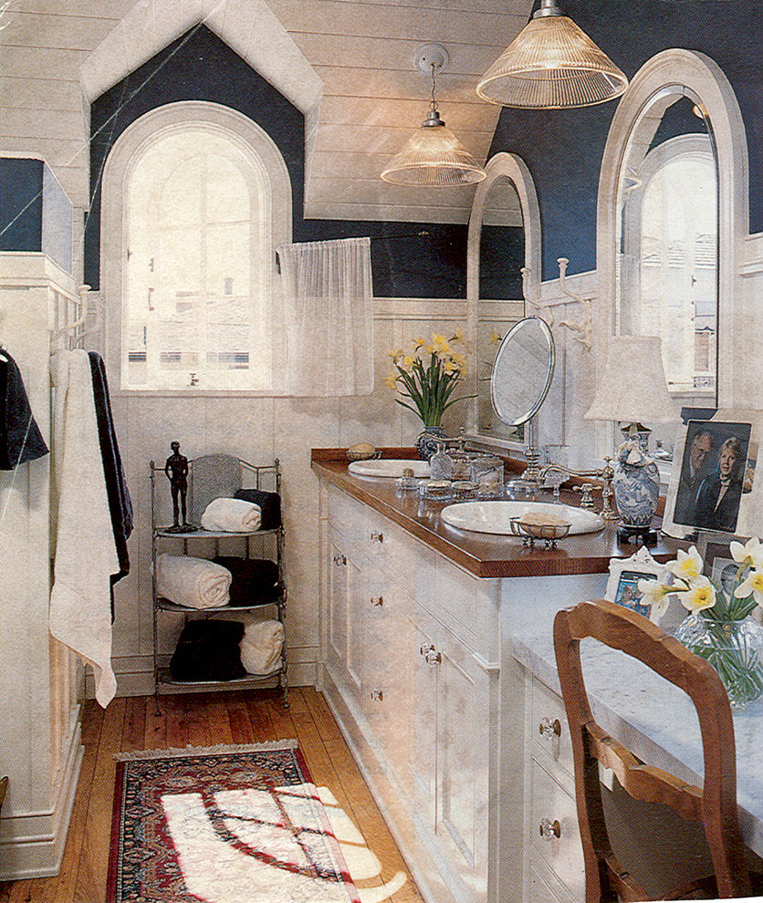 Exempel på ett mellanstort klassiskt badrum, med luckor med infälld panel, vita skåp, blå väggar, ljust trägolv och ett nedsänkt handfat