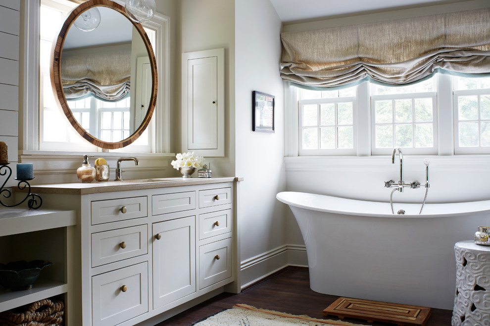 Inredning av ett lantligt badrum, med skåp i shakerstil, grå skåp, ett fristående badkar, vita väggar, ett undermonterad handfat och mörkt trägolv