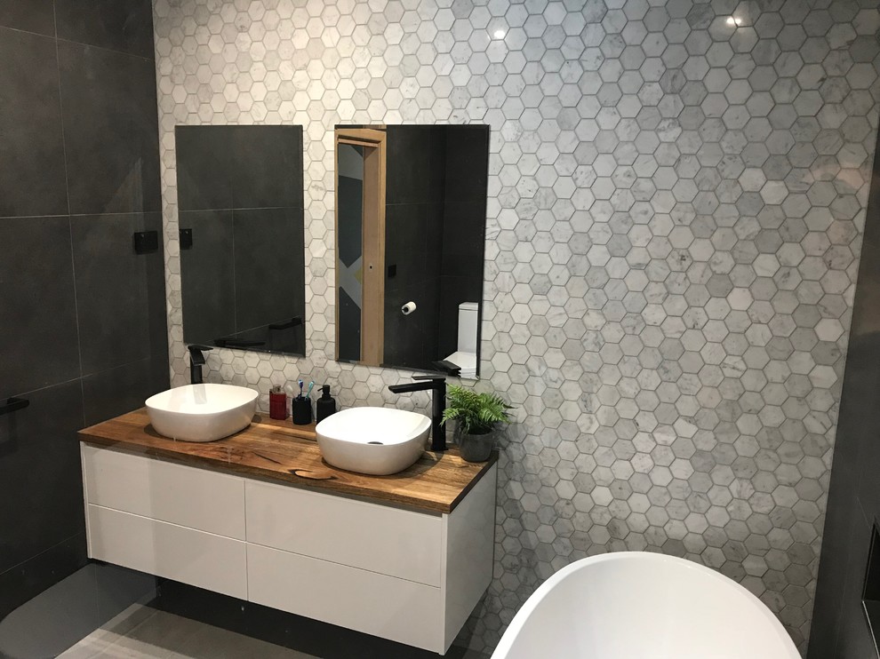 Bathroom - contemporary master ceramic tile bathroom idea in Melbourne with white cabinets, a one-piece toilet, a vessel sink and wood countertops