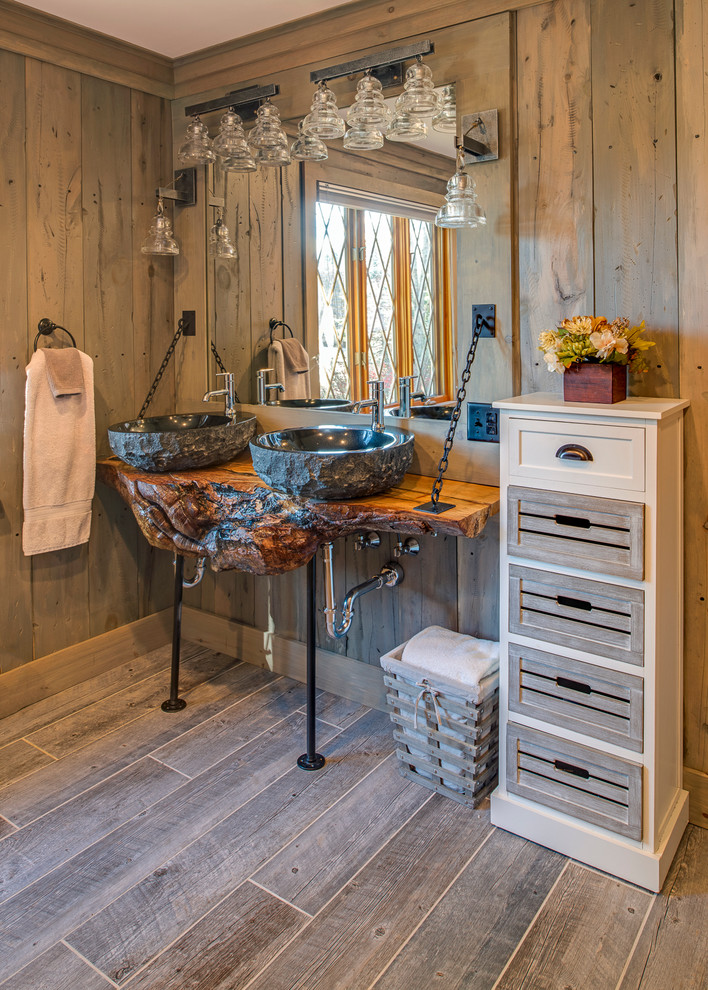 Aménagement d'une salle de bain montagne en bois brun de taille moyenne avec une vasque, un plan de toilette en bois, des carreaux de céramique, un mur gris, un sol en carrelage de céramique et un plan de toilette marron.