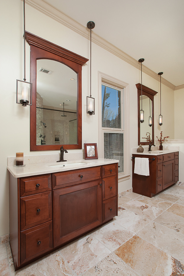 Klassisk inredning av ett mycket stort en-suite badrum, med ett undermonterad handfat, luckor med infälld panel, skåp i mellenmörkt trä, marmorbänkskiva, ett platsbyggt badkar, en kantlös dusch, en toalettstol med separat cisternkåpa, beige kakel, stenkakel, beige väggar och travertin golv