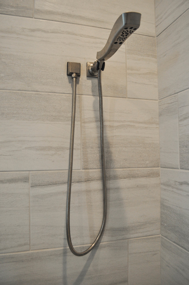 Idee per una stanza da bagno con doccia minimalista di medie dimensioni con doccia ad angolo, piastrelle grigie, piastrelle in gres porcellanato, pareti grigie e porta doccia a battente