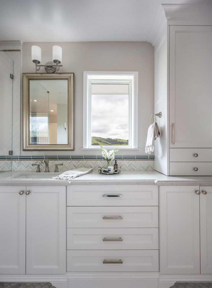 This is an example of a large classic ensuite bathroom in San Francisco with recessed-panel cabinets, white cabinets, a walk-in shower, a one-piece toilet, white tiles, mosaic tiles, white walls, porcelain flooring, a submerged sink, engineered stone worktops, grey floors, a hinged door and white worktops.