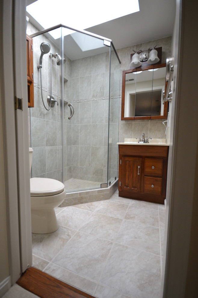 Immagine di una piccola stanza da bagno padronale stile americano con lavabo integrato, ante con bugna sagomata, ante in legno scuro, top in superficie solida, doccia ad angolo e WC monopezzo