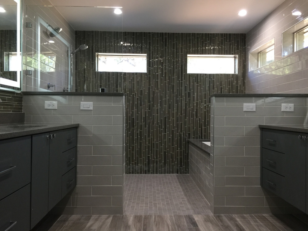 This is an example of a medium sized contemporary ensuite bathroom in Dallas with flat-panel cabinets, grey cabinets, a submerged bath, a walk-in shower, a two-piece toilet, grey tiles, glass sheet walls, grey walls, ceramic flooring, a submerged sink, engineered stone worktops, brown floors, an open shower, grey worktops, a single sink and a floating vanity unit.