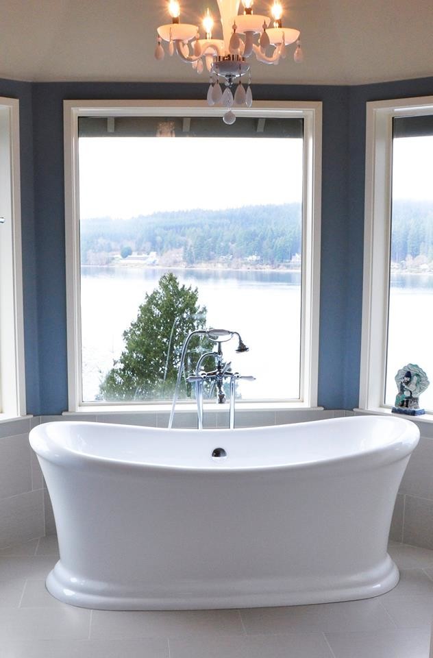 Inspiration for a mid-sized timeless master porcelain tile and gray floor freestanding bathtub remodel in Seattle with raised-panel cabinets, white cabinets, multicolored walls, an undermount sink, granite countertops and black countertops