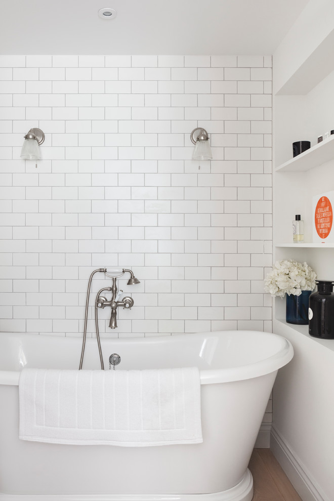 Пример оригинального дизайна: главная ванная комната среднего размера в стиле кантри с отдельно стоящей ванной, белой плиткой, белыми стенами, светлым паркетным полом, подвесной раковиной и плиткой кабанчик