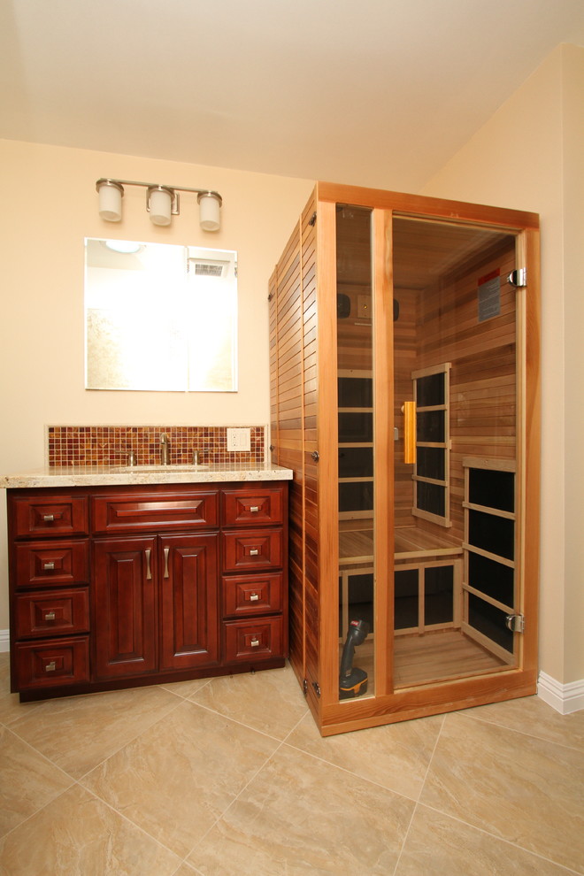 Sauna mit dunklen Holzschränken, Toilette mit Aufsatzspülkasten, beigen Fliesen, Porzellanfliesen, beiger Wandfarbe und Granit-Waschbecken/Waschtisch in Orange County