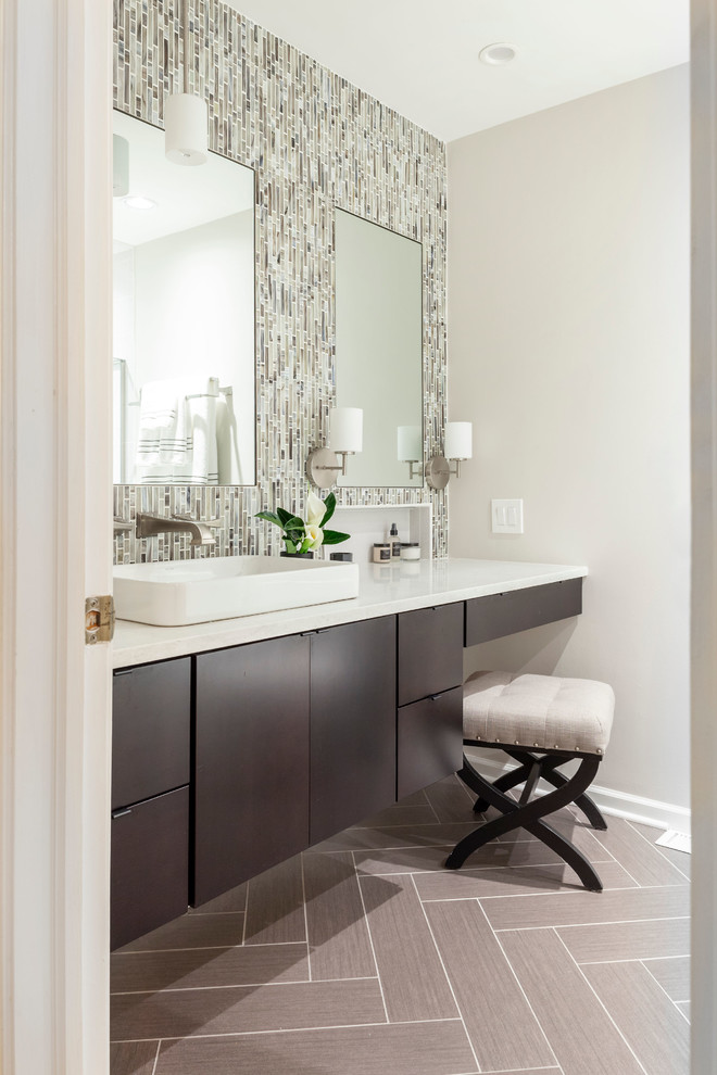 シカゴにあるトランジショナルスタイルのおしゃれな浴室 (フラットパネル扉のキャビネット、濃色木目調キャビネット、グレーの壁、ベッセル式洗面器、グレーの床、白い洗面カウンター) の写真