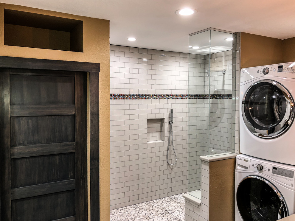 Exempel på ett mellanstort industriellt beige beige badrum med dusch, med släta luckor, skåp i mörkt trä, en kantlös dusch, en toalettstol med hel cisternkåpa, vit kakel, keramikplattor, gula väggar, betonggolv, ett integrerad handfat, bänkskiva i akrylsten, grått golv och med dusch som är öppen