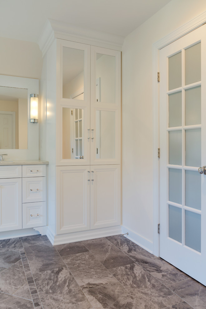 Imagen de cuarto de baño principal tradicional renovado de tamaño medio con armarios con paneles empotrados, puertas de armario blancas, ducha empotrada, paredes beige, suelo de linóleo, lavabo bajoencimera y encimera de granito