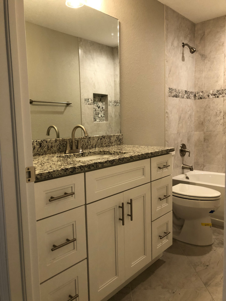 Пример оригинального дизайна: маленькая главная ванная комната в стиле неоклассика (современная классика) с белыми фасадами, угловой ванной, душем над ванной, унитазом-моноблоком, бежевыми стенами, полом из керамической плитки, врезной раковиной, бежевым полом, открытым душем, серой столешницей, тумбой под одну раковину, напольной тумбой, фасадами в стиле шейкер и столешницей из гранита для на участке и в саду