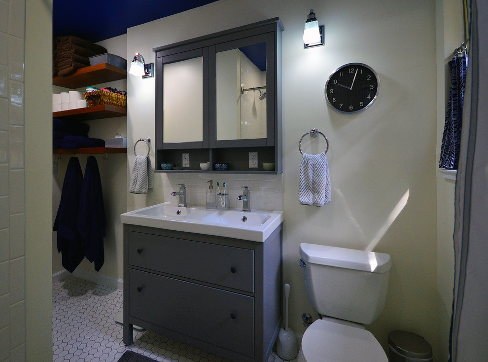 Idéer för att renovera ett mellanstort vintage badrum för barn, med möbel-liknande, grå skåp, ett badkar i en alkov, en dusch/badkar-kombination, en toalettstol med separat cisternkåpa, vit kakel, tunnelbanekakel, beige väggar, mosaikgolv, ett integrerad handfat och vitt golv