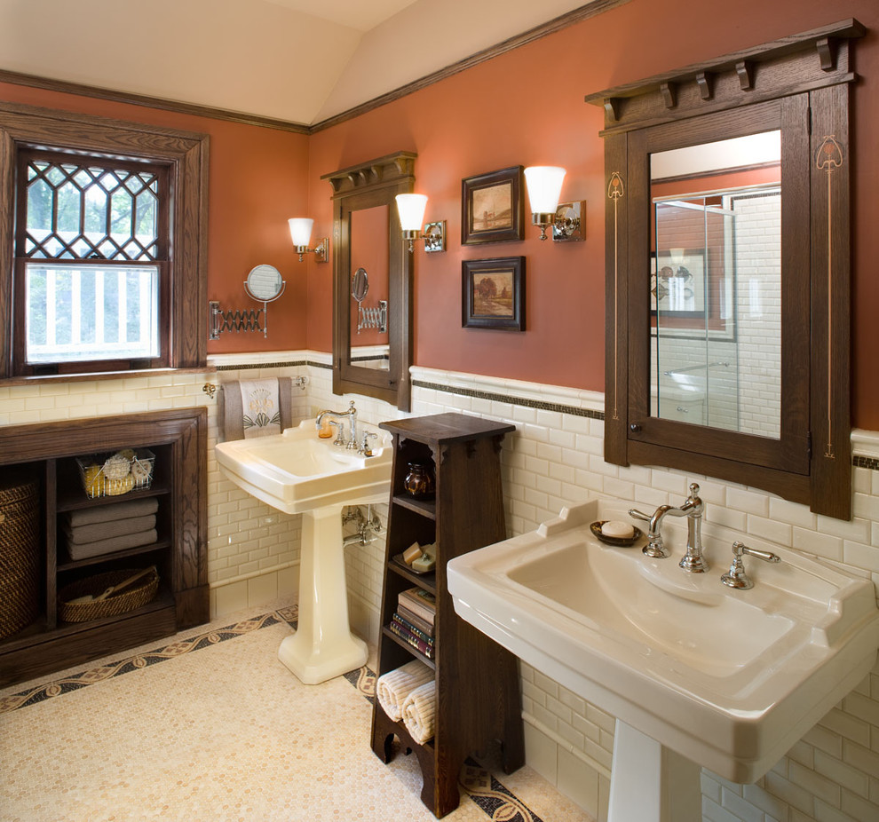 Immagine di una stanza da bagno stile americano con lavabo a colonna e pareti arancioni