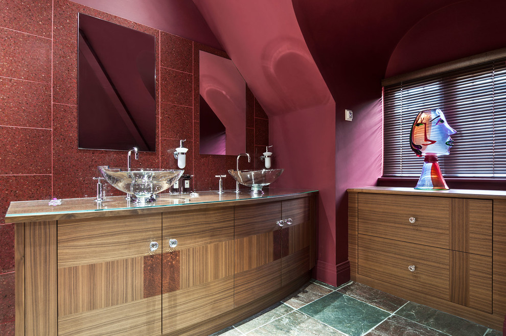 Пример оригинального дизайна: большая главная ванная комната в современном стиле с плоскими фасадами, светлыми деревянными фасадами, красной плиткой, каменной плиткой, красными стенами, мраморным полом, настольной раковиной и стеклянной столешницей