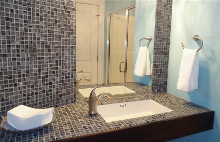 Inspiration pour une salle de bain design de taille moyenne avec mosaïque, un carrelage marron, un carrelage gris, un carrelage multicolore, un mur bleu, un lavabo encastré et un plan de toilette en carrelage.