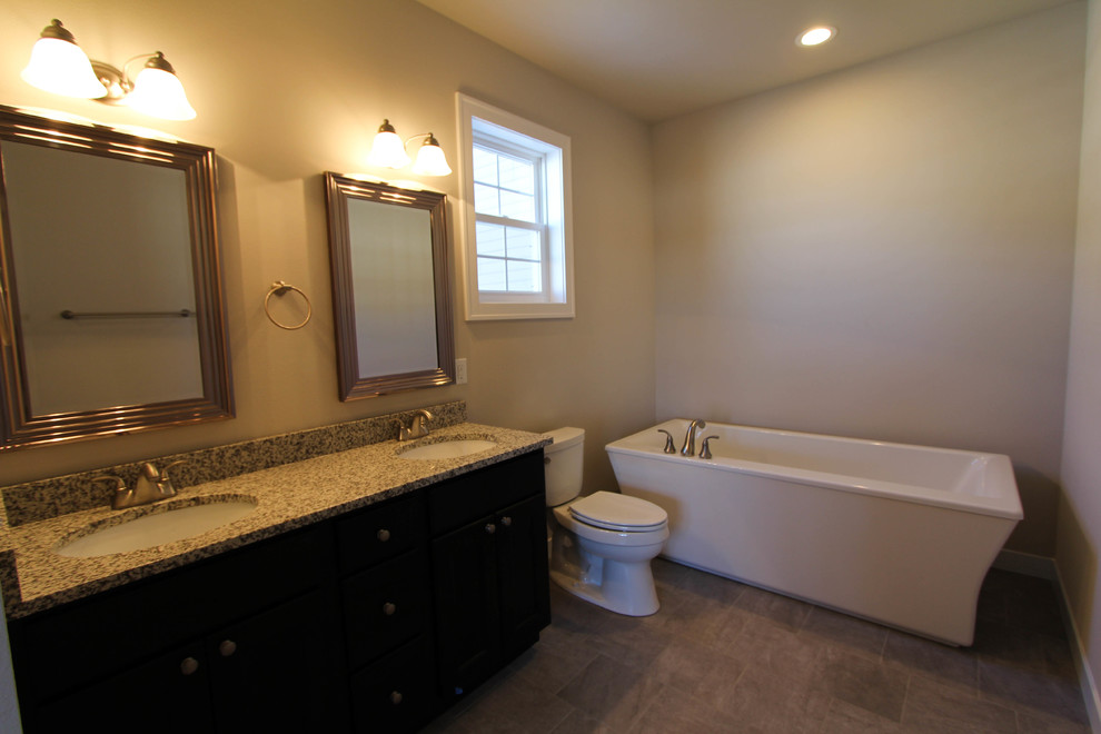 На фото: главная ванная комната в стиле неоклассика (современная классика) с темными деревянными фасадами, столешницей из гранита, серой плиткой, керамогранитной плиткой и полом из керамогранита с