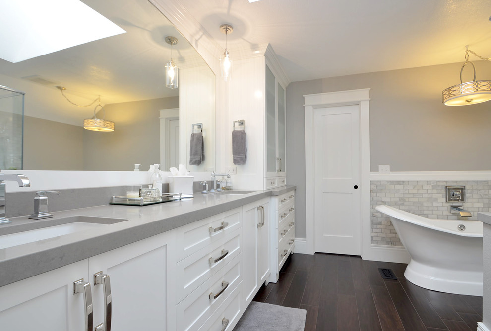 Bathroom - mid-sized transitional master gray tile and stone tile porcelain tile bathroom idea in Denver with an undermount sink, recessed-panel cabinets, white cabinets, granite countertops, gray walls and a one-piece toilet