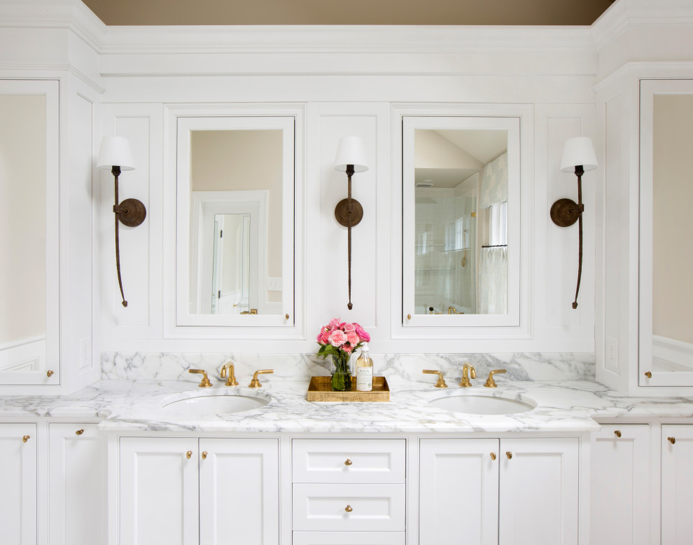 Inspiration for a large timeless master white tile and ceramic tile marble floor, beige floor, double-sink, vaulted ceiling and wainscoting bathroom remodel in Philadelphia with recessed-panel cabinets, white cabinets, a two-piece toilet, beige walls, an undermount sink, marble countertops, a hinged shower door, white countertops and a built-in vanity