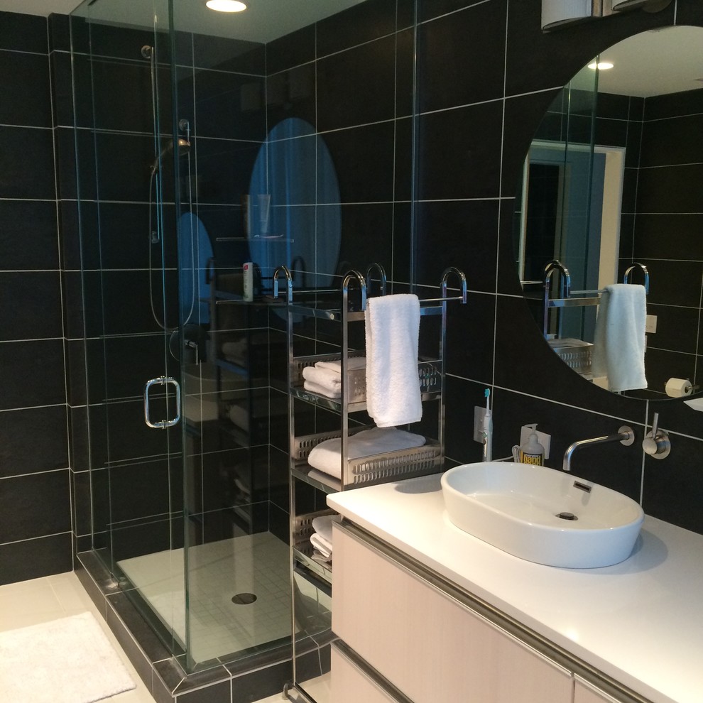 Пример оригинального дизайна: большая главная ванная комната в современном стиле с врезной раковиной, белыми фасадами, угловой ванной, угловым душем, черной плиткой и разноцветными стенами