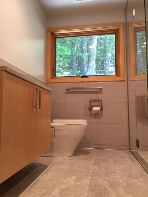 Imagen de cuarto de baño minimalista pequeño con armarios con paneles lisos, puertas de armario de madera clara, paredes beige, suelo de baldosas de cerámica y aseo y ducha