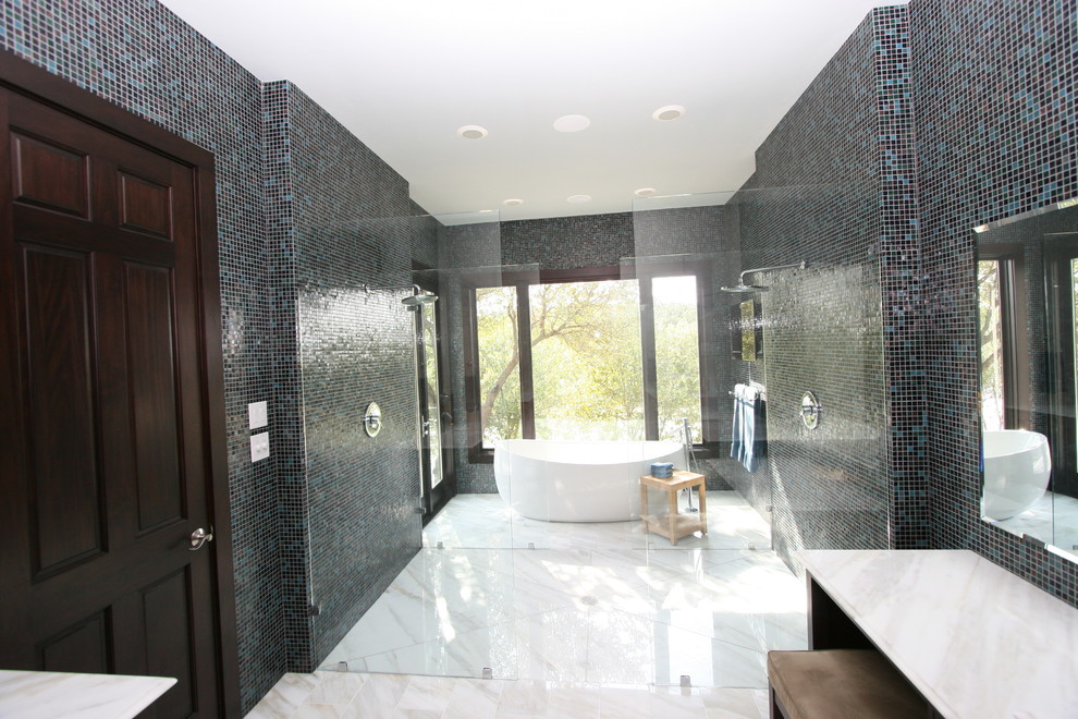 Cette image montre une grande salle de bain principale minimaliste avec un placard à porte plane, des portes de placard noires, une baignoire indépendante, une douche double, un carrelage noir, un carrelage bleu, un carrelage multicolore, mosaïque, un mur multicolore, un lavabo encastré et un plan de toilette en granite.