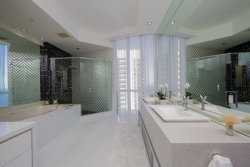 Пример оригинального дизайна: большая главная ванная комната в стиле модернизм с плоскими фасадами, белыми фасадами, гидромассажной ванной, угловым душем, черной плиткой, черно-белой плиткой, белой плиткой, плиткой мозаикой, разноцветными стенами, накладной раковиной и столешницей из кварцита