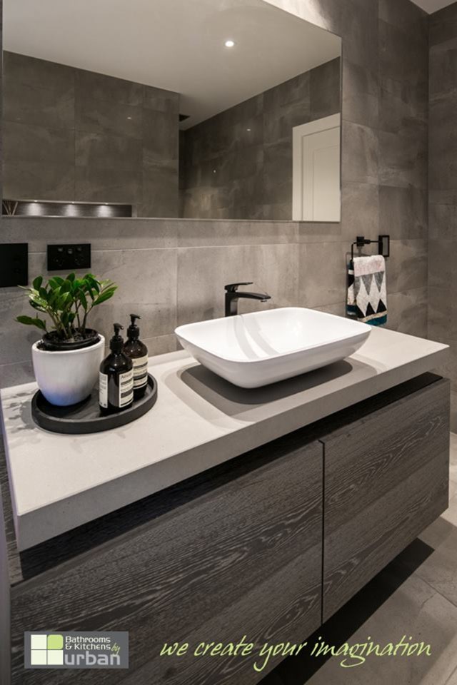 Modern inredning av ett stort badrum med dusch, med möbel-liknande, grå skåp, ett fristående badkar, en dusch i en alkov, grå kakel, cementkakel, grå väggar och klinkergolv i keramik