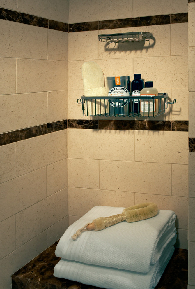 Идея дизайна: главная ванная комната среднего размера в классическом стиле с врезной раковиной, фасадами с утопленной филенкой, темными деревянными фасадами, мраморной столешницей, ванной в нише, душем над ванной, раздельным унитазом, бежевой плиткой, каменной плиткой, бежевыми стенами и полом из известняка
