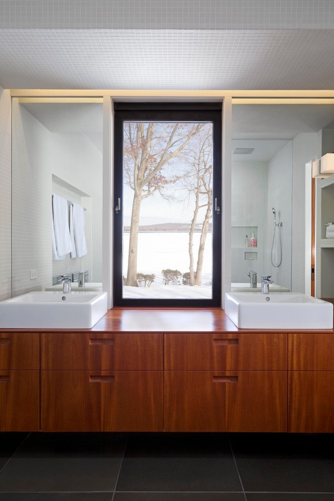 Inredning av ett klassiskt mellanstort en-suite badrum, med möbel-liknande, skåp i mellenmörkt trä, en toalettstol med hel cisternkåpa, vit kakel, vita väggar, betonggolv, ett fristående handfat, träbänkskiva, grått golv, en kantlös dusch, keramikplattor och med dusch som är öppen