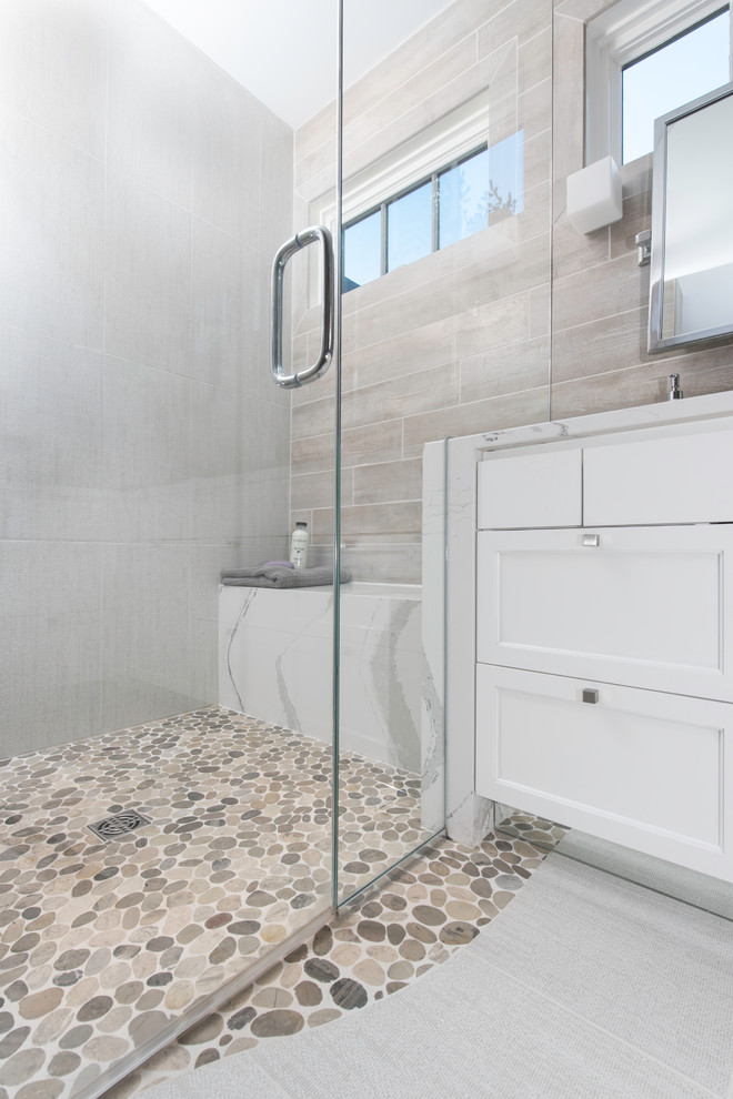 Walk-in shower - mid-sized contemporary master gray tile and porcelain tile porcelain tile and white floor walk-in shower idea in New York with recessed-panel cabinets, white cabinets, gray walls, an undermount sink, quartz countertops and a hinged shower door