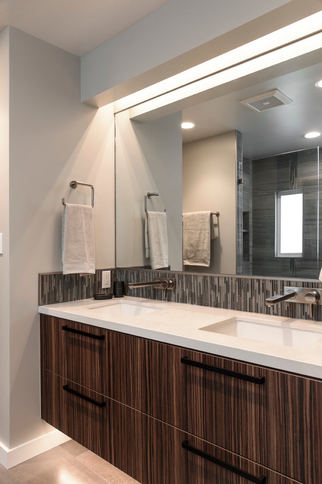 Idee per una stanza da bagno padronale moderna con ante lisce, ante in legno bruno, piastrelle grigie, pavimento con piastrelle in ceramica, lavabo sottopiano e top in quarzo composito