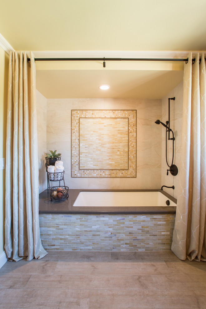 Cette image montre une grande salle de bain principale traditionnelle avec un plan de toilette en quartz modifié, une baignoire encastrée, un combiné douche/baignoire, un carrelage beige, un carrelage en pâte de verre, un mur jaune et un sol en carrelage de porcelaine.