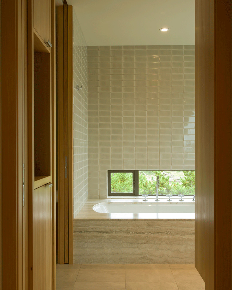 Идея дизайна: ванная комната с ванной в нише, бежевой плиткой и окном