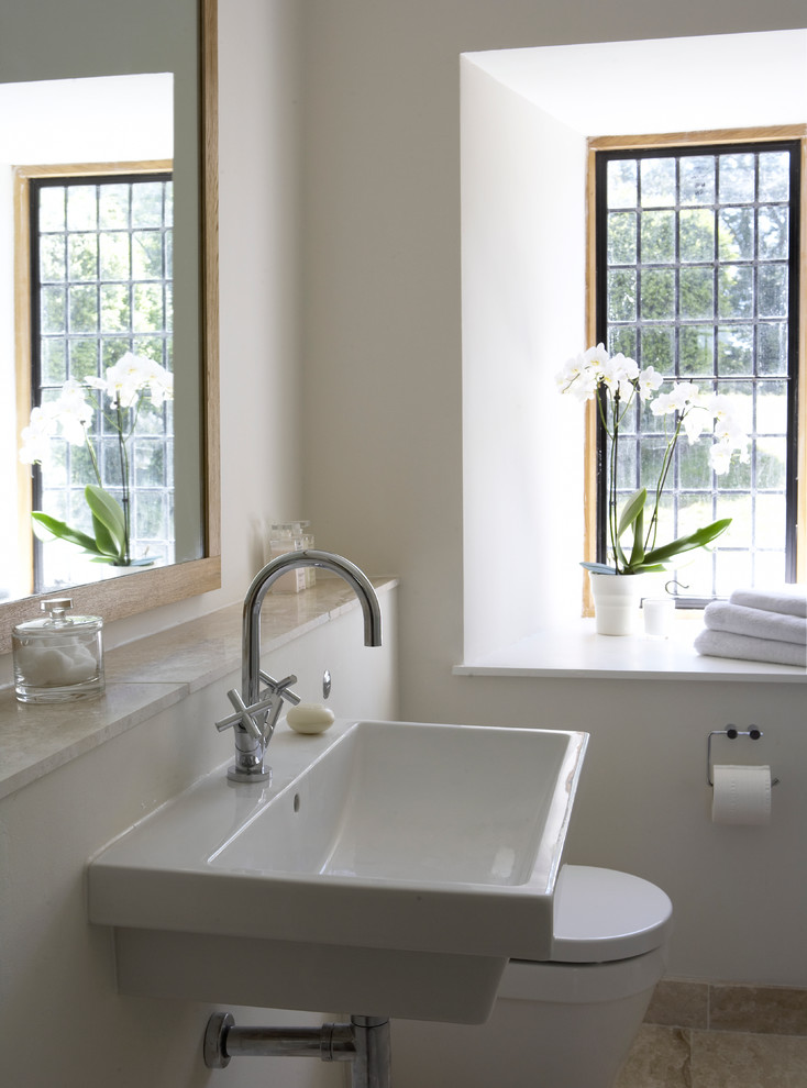 Inspiration för små moderna badrum, med ett väggmonterat handfat, ett fristående badkar, en vägghängd toalettstol, beige kakel, stenkakel, beige väggar, kalkstensgolv, en öppen dusch och träbänkskiva