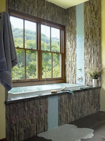 Esempio di una stanza da bagno padronale rustica di medie dimensioni con vasca da incasso, piastrelle grigie, piastrelle in pietra, pareti gialle, pavimento in gres porcellanato e pavimento grigio