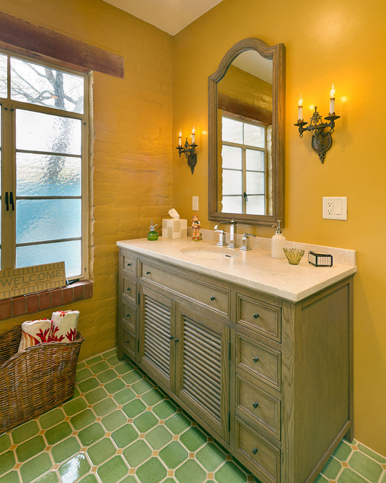 Inredning av ett klassiskt badrum, med ett undermonterad handfat, luckor med lamellpanel, skåp i mellenmörkt trä, gula väggar och grönt golv