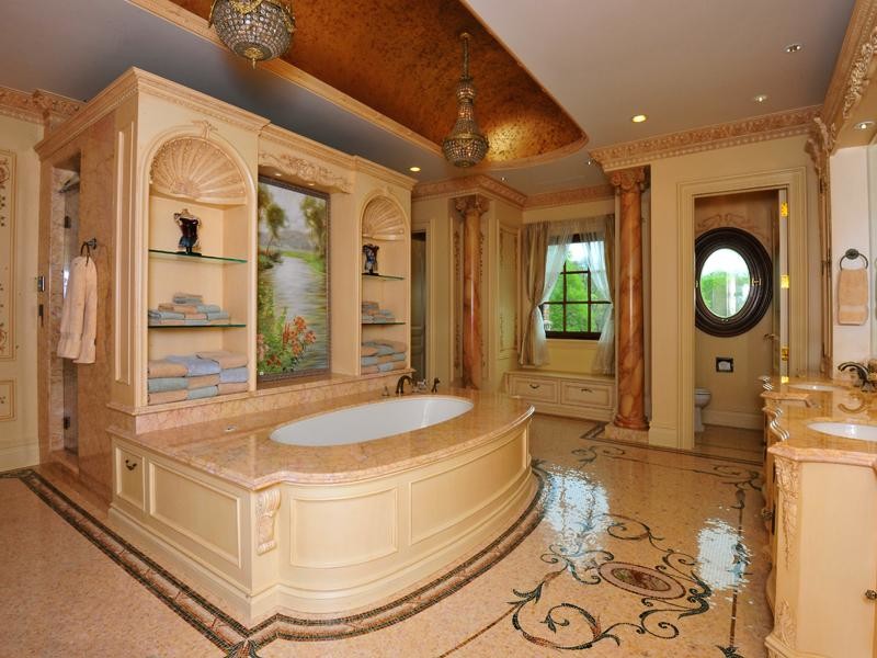 Diseño de cuarto de baño principal tradicional grande con puertas de armario beige, bañera empotrada, paredes beige, suelo con mosaicos de baldosas, lavabo bajoencimera, encimera de mármol y suelo marrón