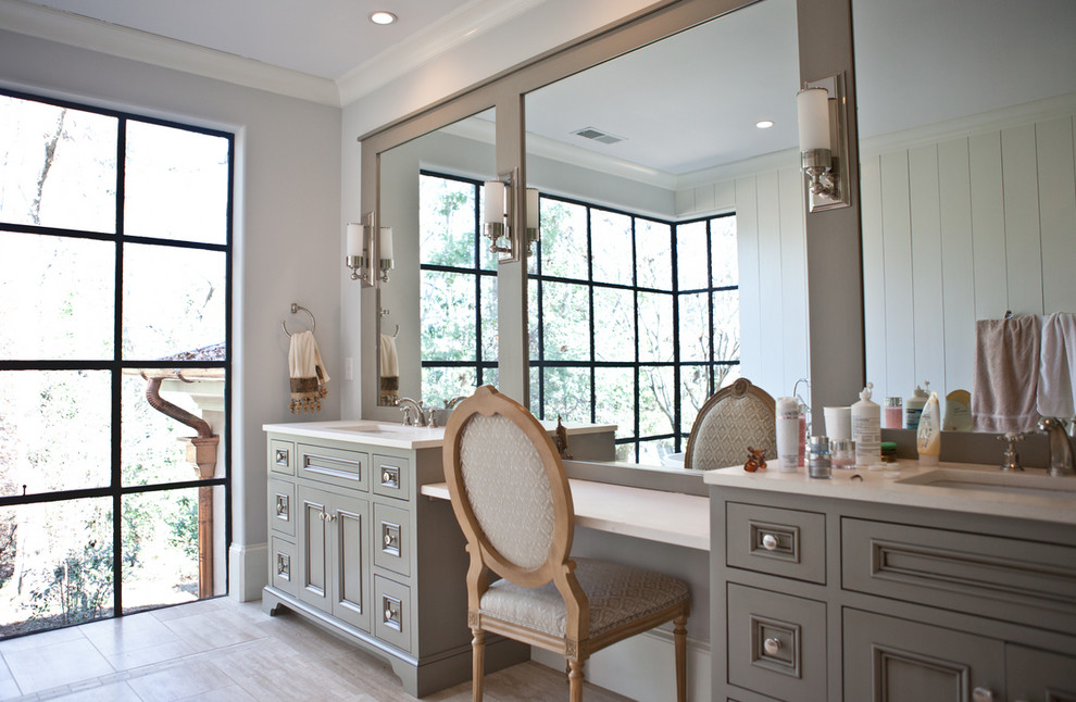 Photo of a large contemporary ensuite bathroom in Atlanta with beaded cabinets, beige cabinets, a freestanding bath, grey walls, porcelain flooring, a submerged sink, solid surface worktops and beige floors.