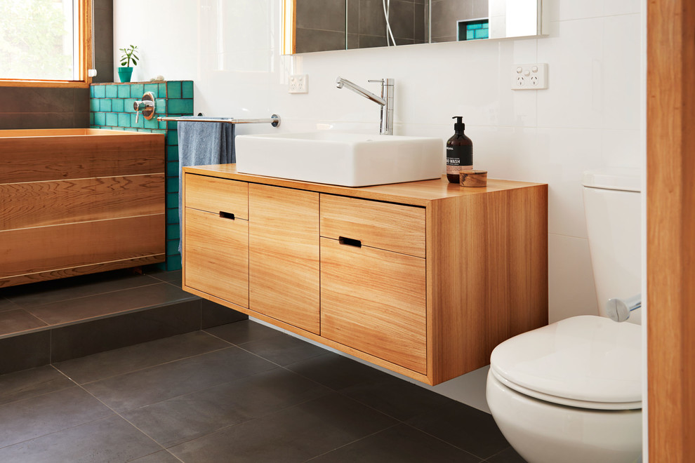Exemple d'une salle de bain rétro en bois clair de taille moyenne avec un placard en trompe-l'oeil et un plan de toilette en bois.